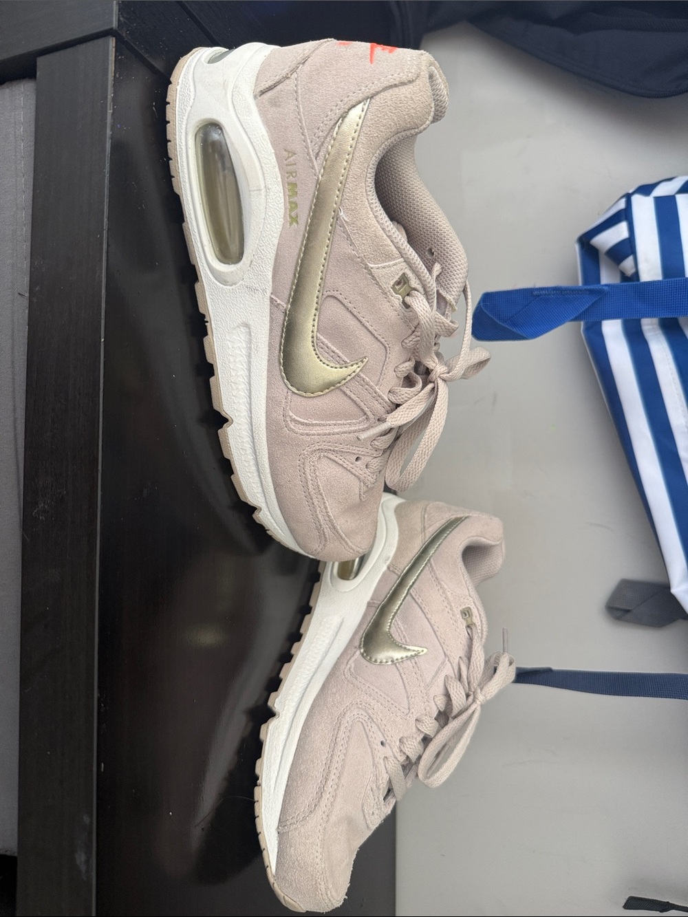 Nike Air Max Women's Sneakers in Light Pink with Metallic Gold Swoosh.